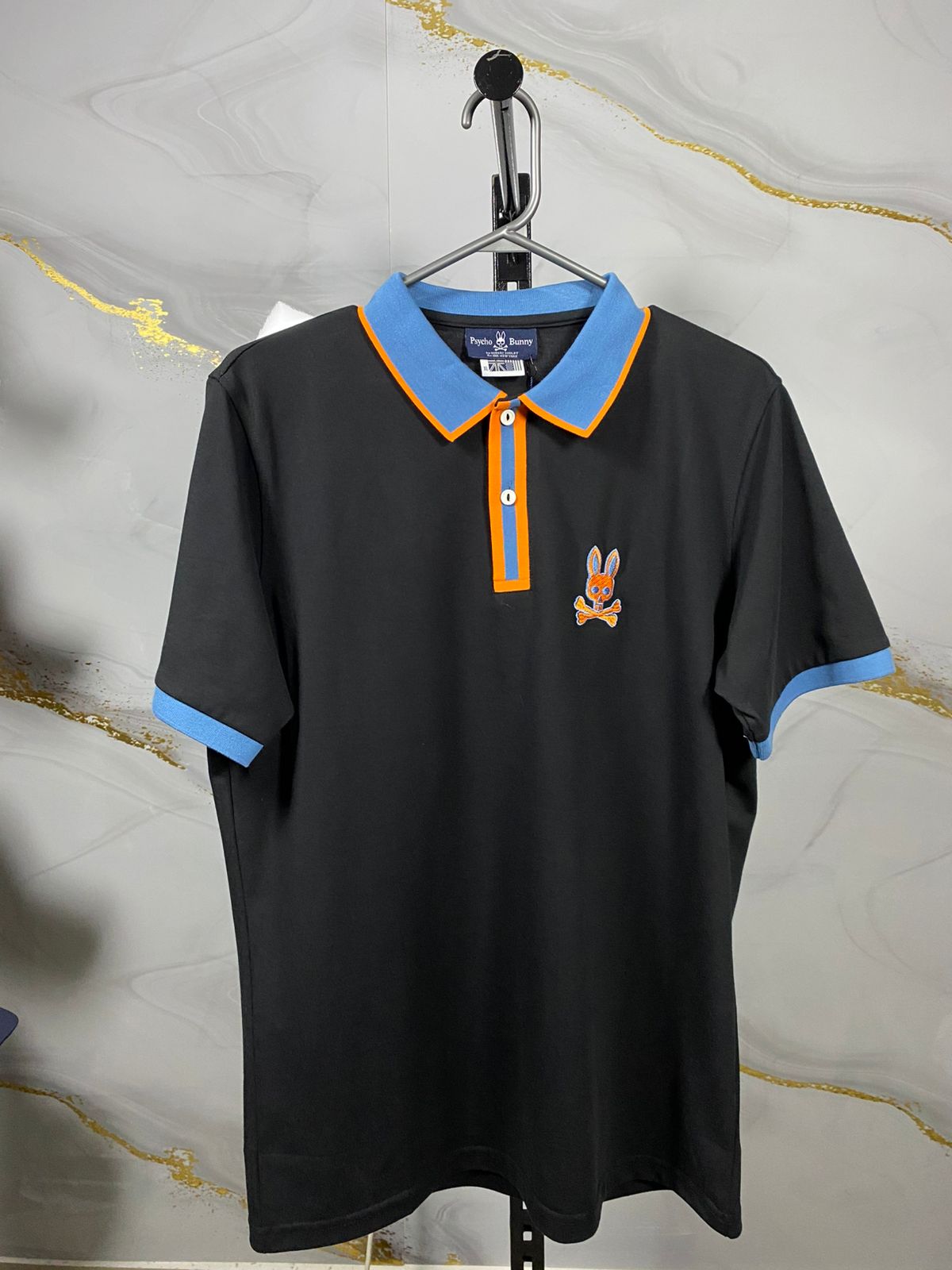 psycho-bunny-XL-cuello-azul-claro-borde-naranja.jpeg